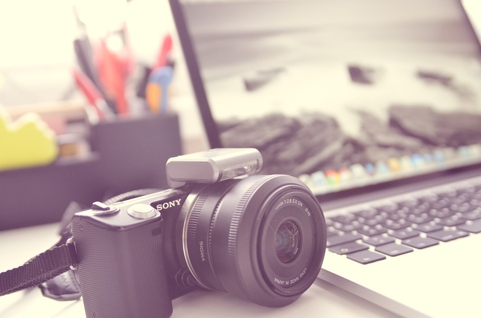 camera on a desk by a laptop