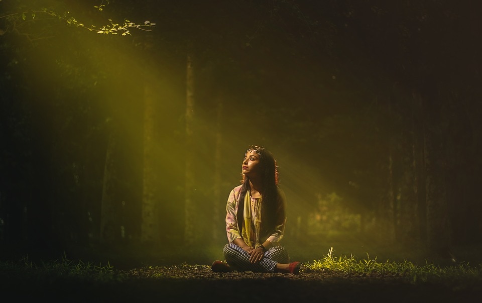 woman meditating with a bad aura in the forest