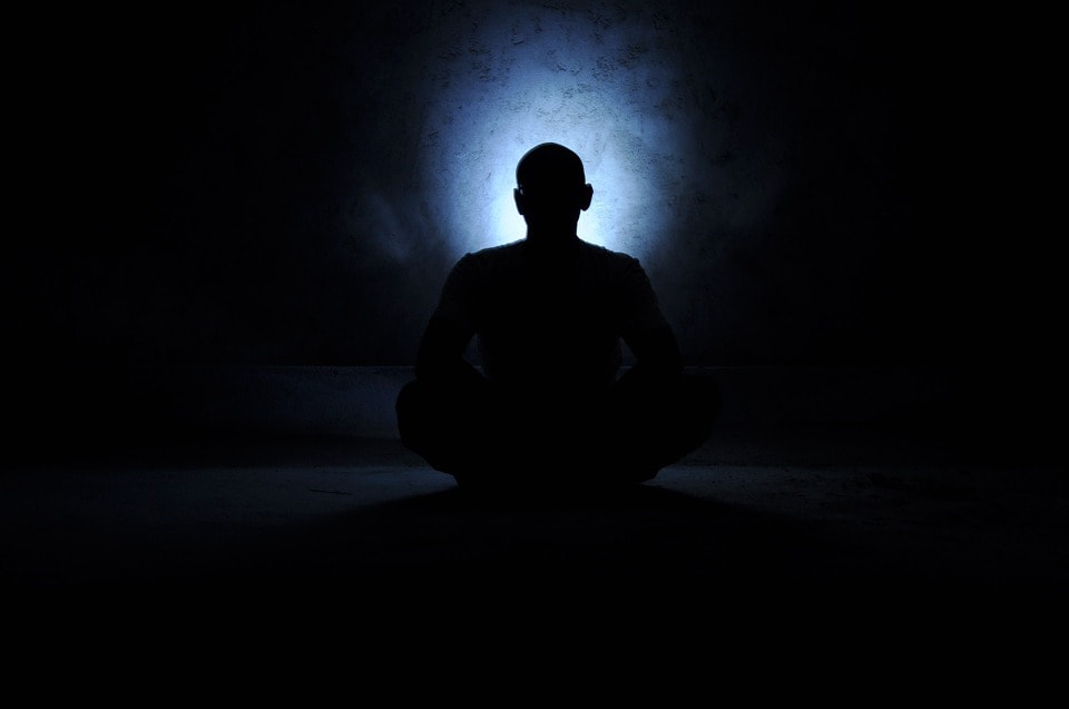 person meditating with a blue aura